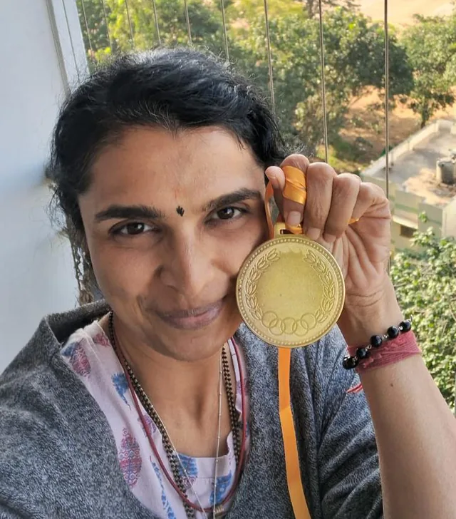 A FitwithPari winner holding her gold medal