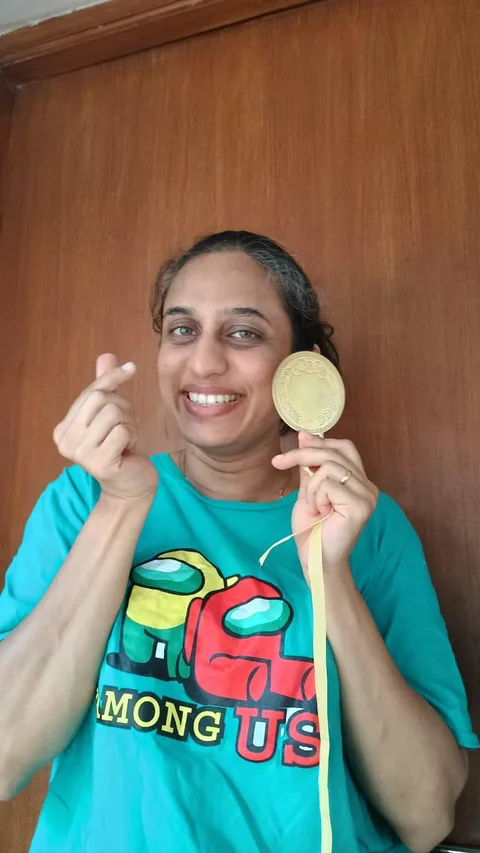 A FitwithPari winner smiling with her medal