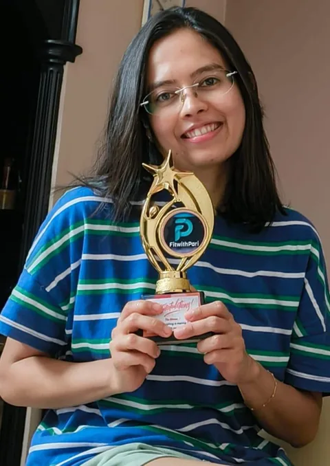 A FitwithPari winner showing her leaderboard trophy