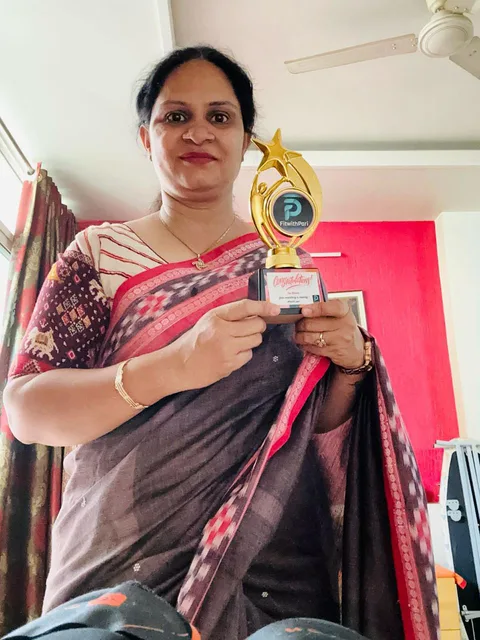 A FitwithPari winner in a sari with her trophy