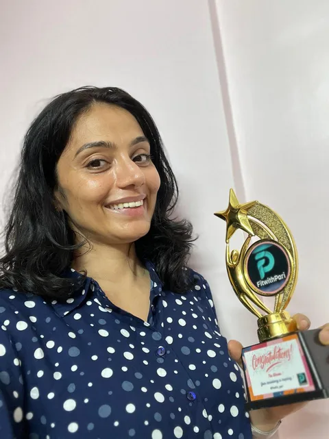 A FitwithPari winner taking a selfie with her trophy